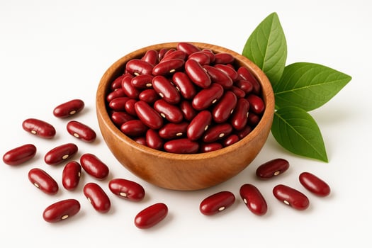 A wooden bowl filled with red beans stands on a white background. There are a few beans scattered around. Green leaves . photo