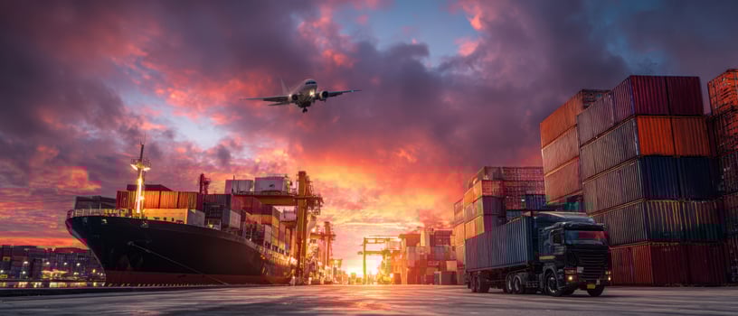 The vibrant sunset over a busy harbor featuring a cargo ship and airplane. photo