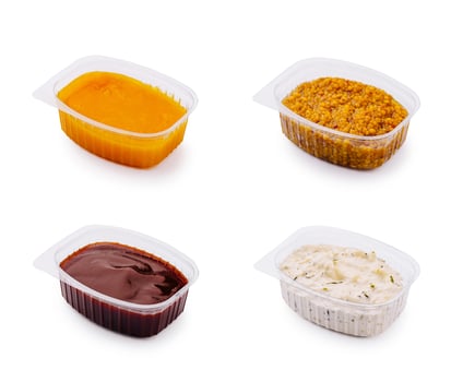 Savory barbecue sauce in clear plastic container on a white back photo
