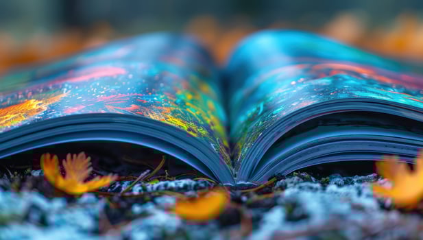 Open book displaying abstract design resting on autumn leaves photo