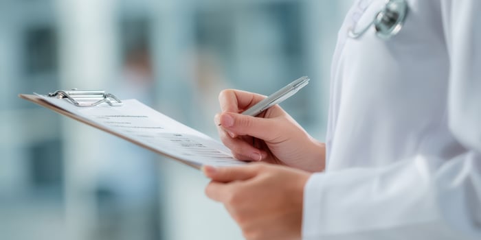 The doctor reviewing important notes while conducting a patient examination. photo