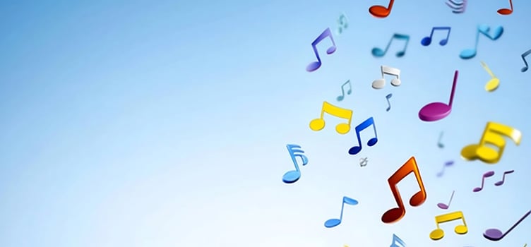 Colorful musical notes falling against a blue sky photo