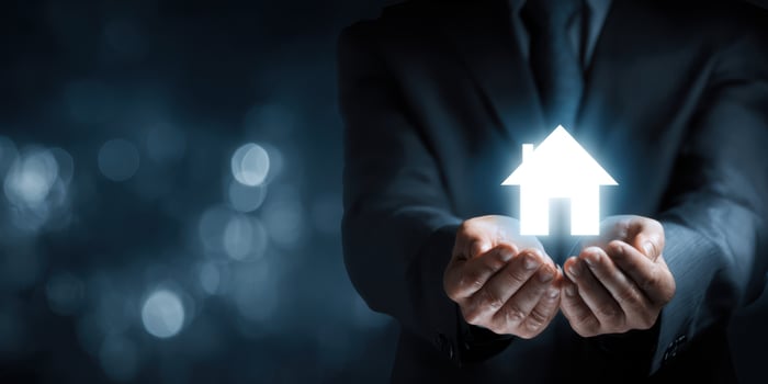 The hands holding a glowing house symbolizing real estate investment and security. photo