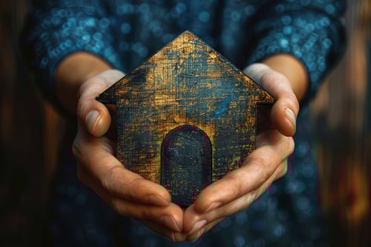Wooden house held in hands symbolizing home security and protection photo