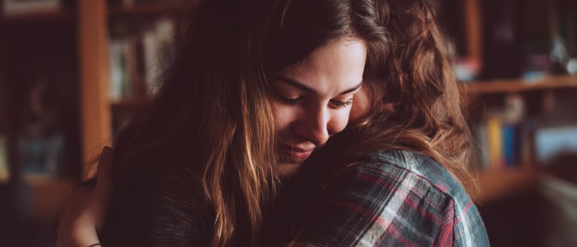 The intimate moment of two friends sharing a warm embrace at home. photo