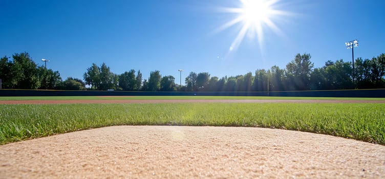Pitchers mound, sunny baseball field, trees photo