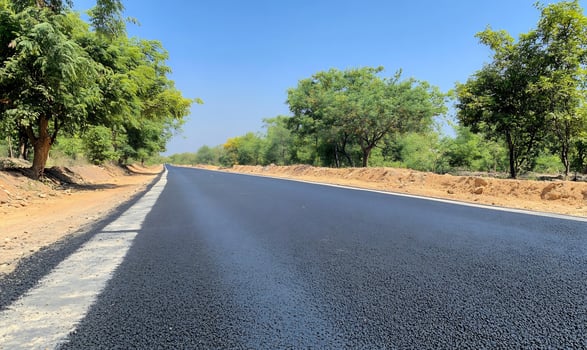 New asphalt road through rural India, sunny day photo