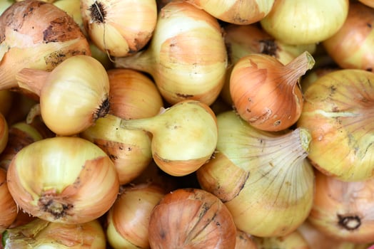 Baskets of golden onions and white garlic at the village market. photo