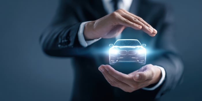 The holographic car displayed between hands demonstrating innovative technology solutions. photo