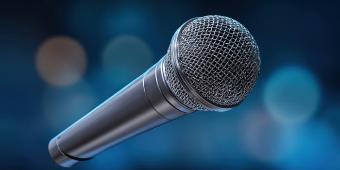 The microphone floating against a blurred blue background with vibrant lights. photo