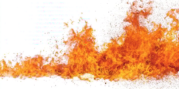 The dynamic flames dancing in bright orange against a white background. photo