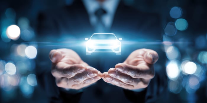 The businessman showcases a holographic car in his hands. photo