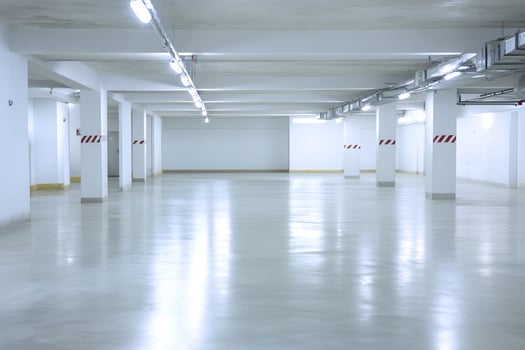 Empty underground parking garage, clean floor, white walls photo