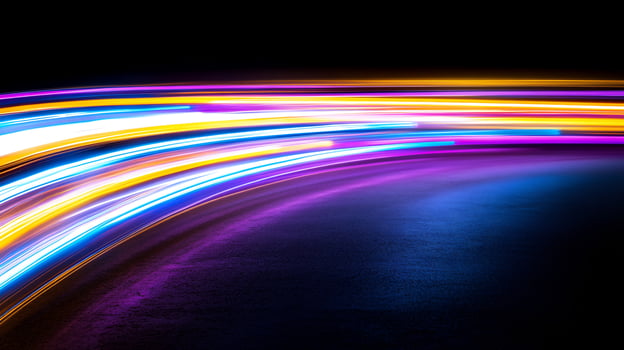 Colorful light trails curve on road at night photo