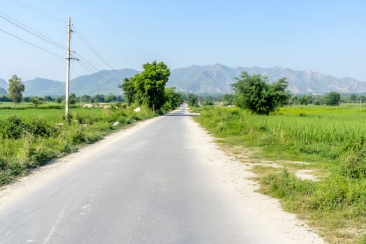 Rural road, mountains background, farmland, sunny day, travel photo