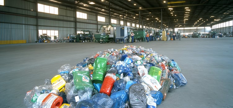 Plastic recycling facility workers sort bottles pile foreground photo