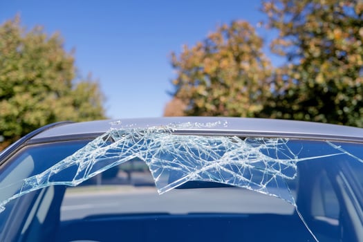 Cracked car windshield, autumn day, street photo