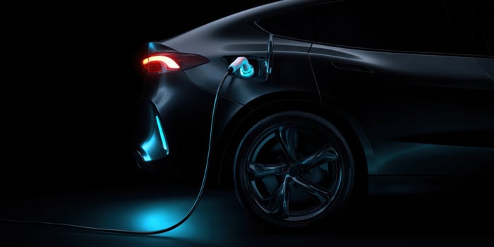The sleek electric car charging with glowing lights in a dark setting. photo