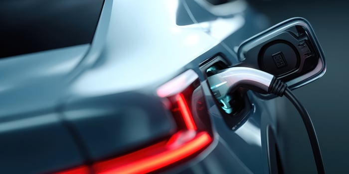 The electric car charging with a sleek plug at an urban charging station. photo