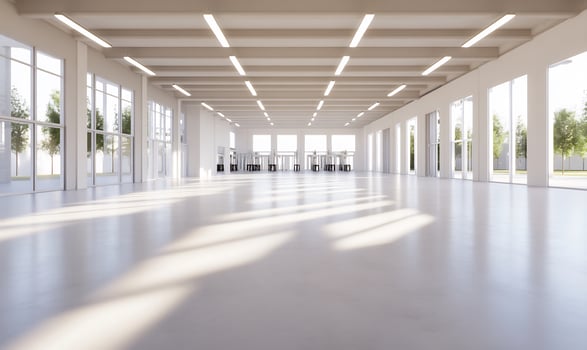 Bright, spacious warehouse sunlight streams through large windows trees outside photo