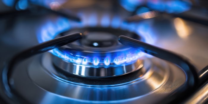 The gas burner producing a vibrant blue flame for cooking purposes. photo