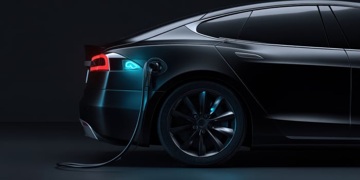 The sleek electric car charging under dramatic ambient lighting. photo