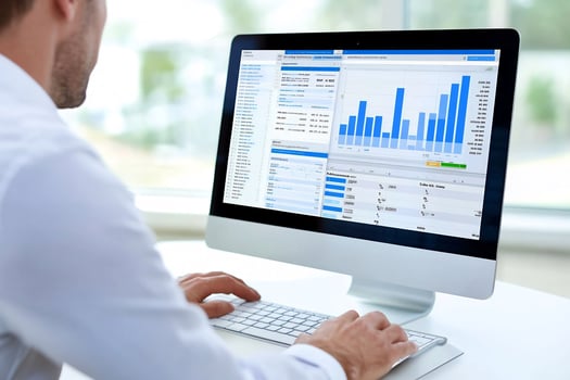 Businessman analyzing data on computer in office photo