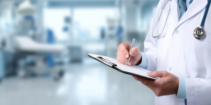 The doctor writing notes in a modern healthcare facility with a clipboard. photo