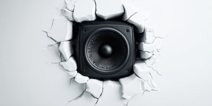 The Black Speaker Breaking Through a White Wall with Cracked Texture photo
