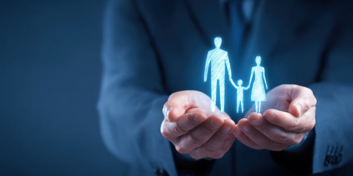 The hands holding a glowing family hologram symbolizing care and protection. photo