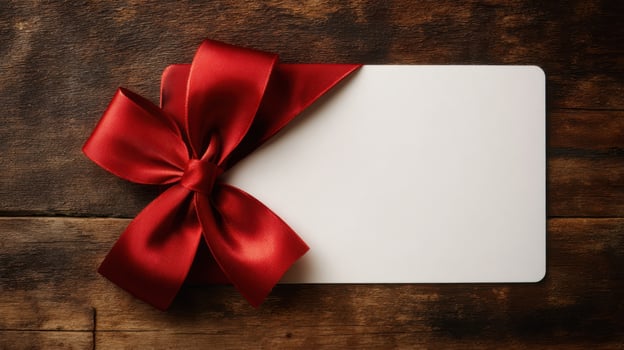 The elegant gift card adorned with a luxurious red bow on wooden backdrop. photo