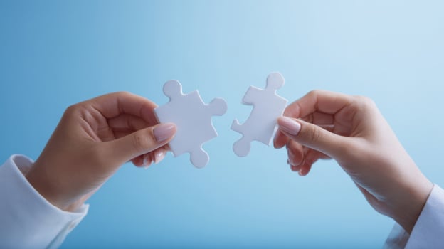 The hands connecting two white puzzle pieces in a collaborative gesture. photo