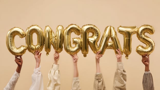 The Hands Holding Golden Balloons Spelling Congrats in Celebration photo