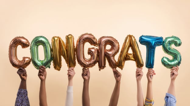The colorful collection of hands holding congratulatory balloon letters. photo