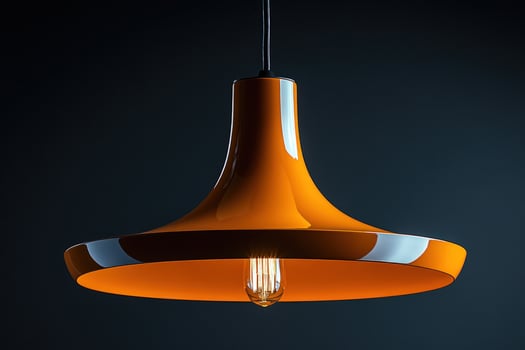 Stylish orange pendant lamp fixture illumination against a dark backdrop interior design and decoration photo