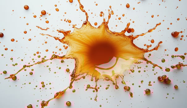 Abstract liquid splash amber fluid explosion on white surface background photo