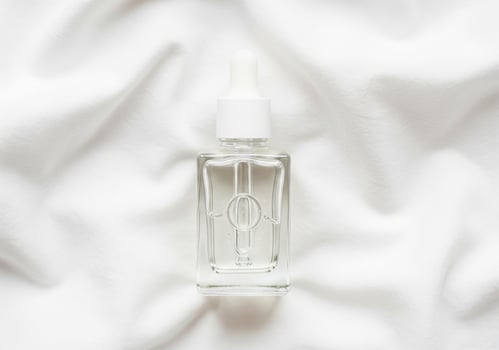 skincare oil in square bottle on cotton cloth for natural beauty visuals photo