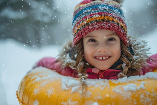 Child on inflatable tube having winter fun in the snow photo