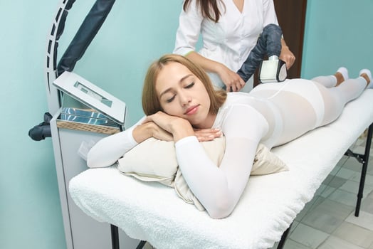 Young caucasian female relaxing during beauty treatment with massage device in spa setting. photo