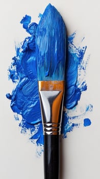 Paintbrush with blue paint on white background studio shot photo