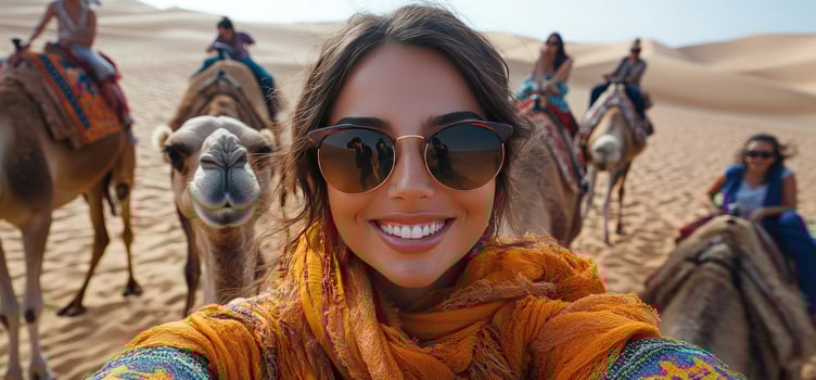 Woman riding camel taking selfie in desert landscape photo