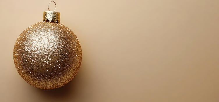 Golden glitter ornament on beige background holiday decoration photo