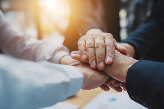 A group of colleagues stacking their hands in a gesture of teamwork and collaboration. photo