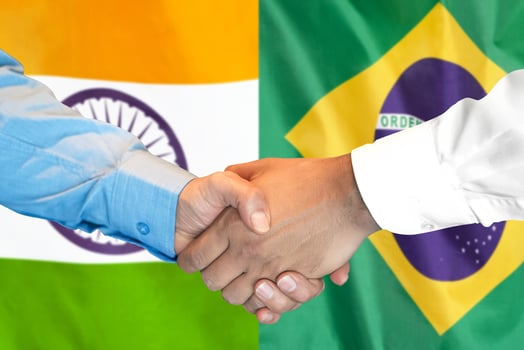 handshake on Brazil and India flag background. photo