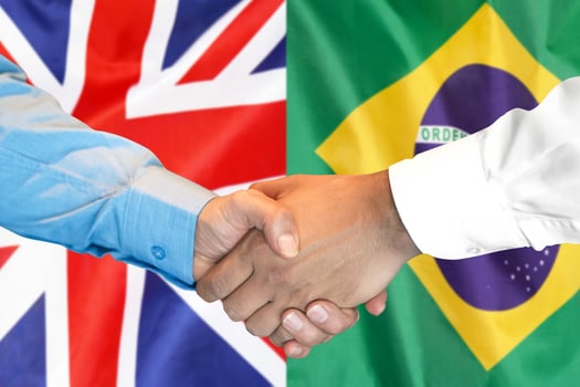 handshake on Brazil and UK flag background. photo