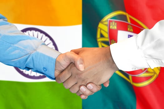 handshake on Portugal and India flag background. photo