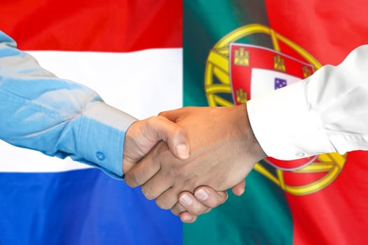 handshake on Portugal and Netherlands flag background. photo