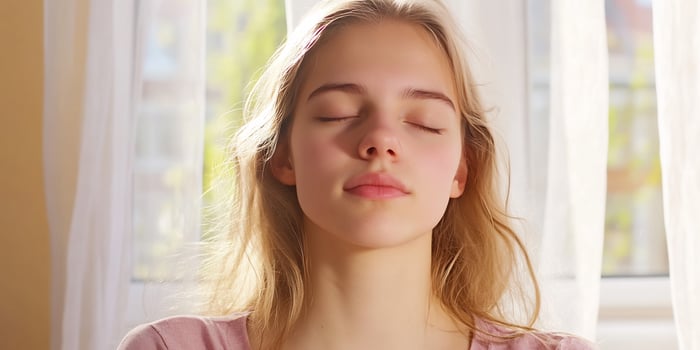 Teen girl meditating, sunlight, window, peace photo