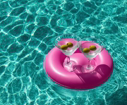 Two glasses of martini on a float in a pool photo