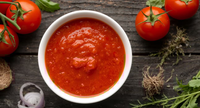 Fresh Tomato Sauce in White Bowl on Dark Wood Surface, Surrounded by Ingredients. photo